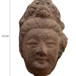 Head of a Galbinga sculpture with an updo hairstyle and floral hair ornament.