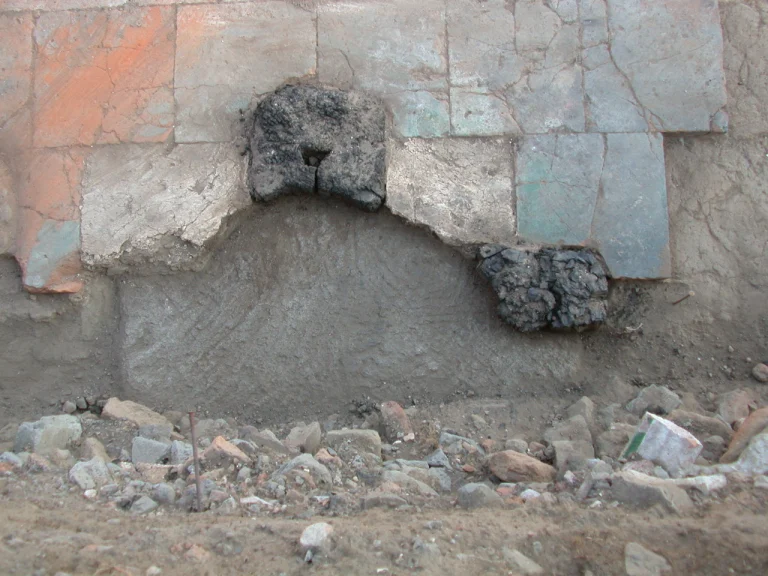 Picture showing part of the floor, the base of a column and burnt wood remains.